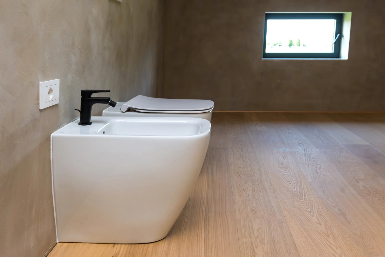Warm plaster bathroom with sculptural white fixtures