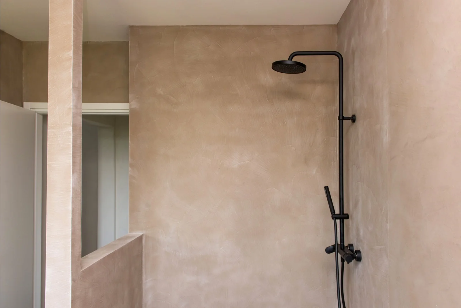 Textured plaster walls and matte black shower fittings