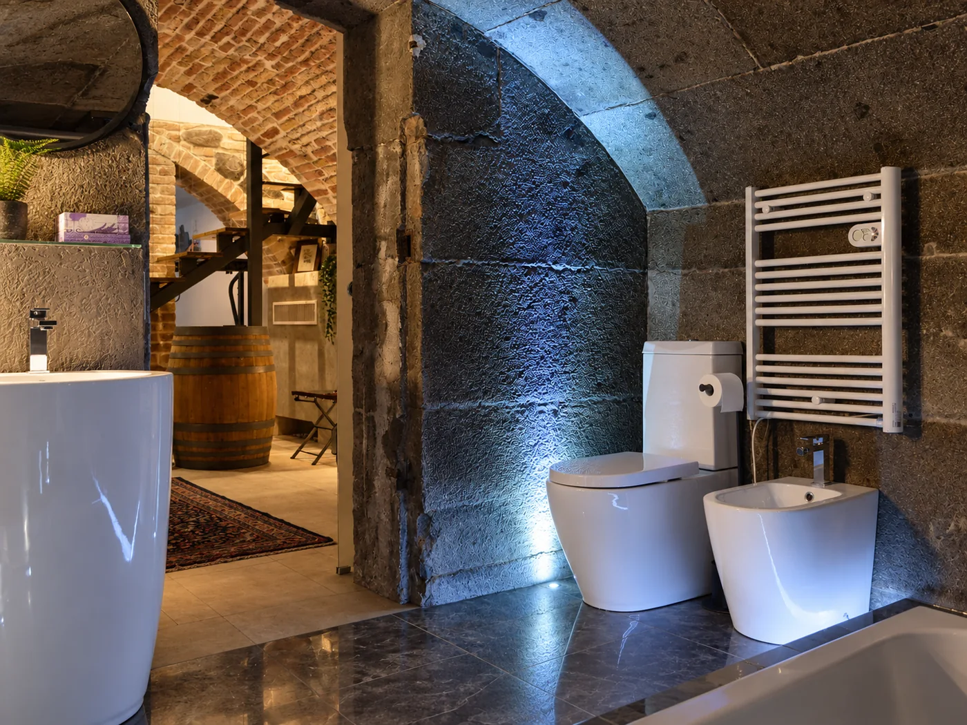 Contemporary bathroom fixtures within a vaulted historic stone interior