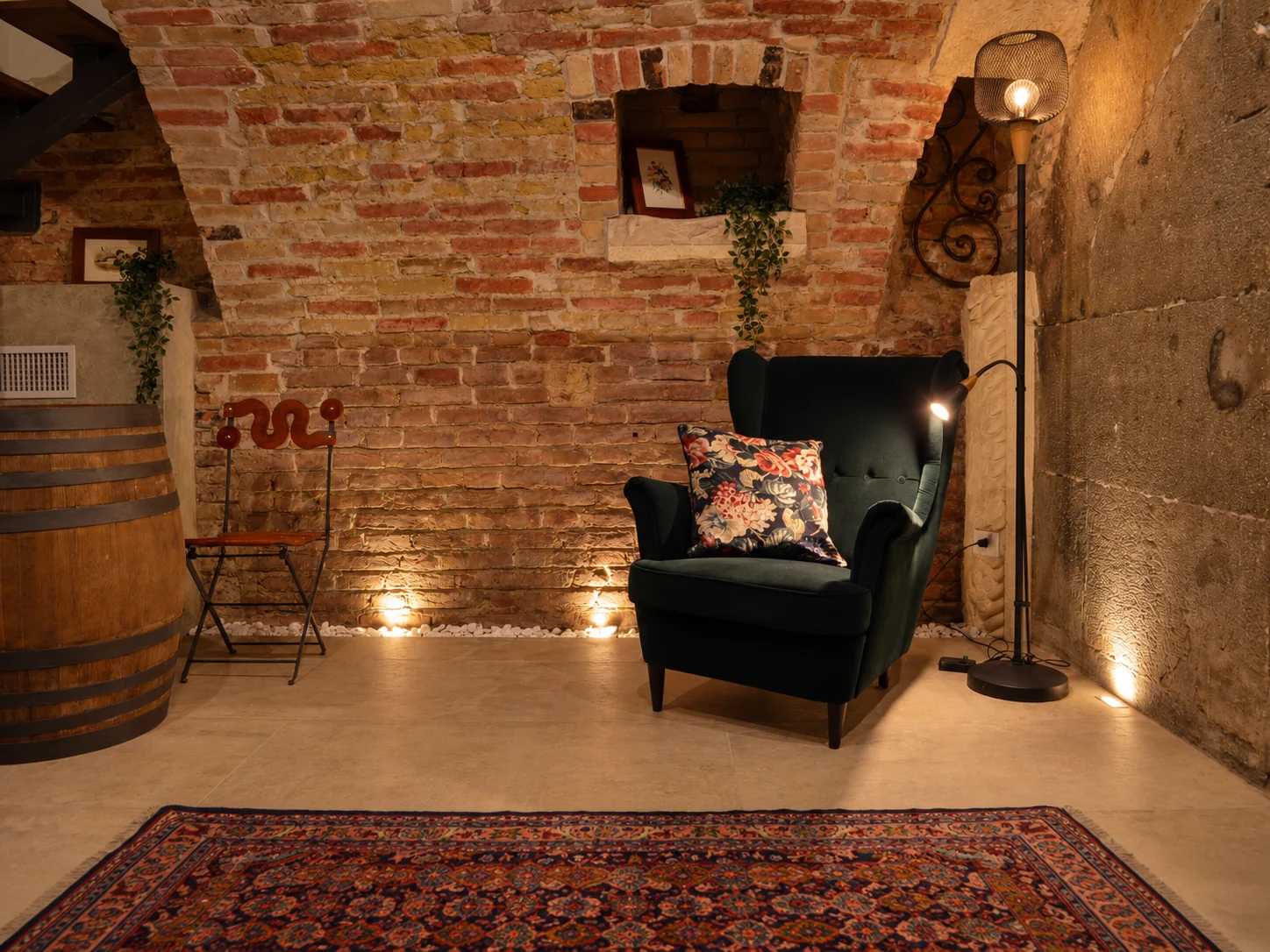 Velvet armchair against an exposed brick wall