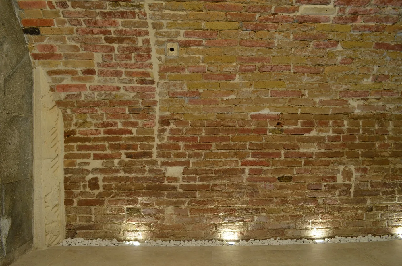 Original exposed brickwork with soft architectural uplighting