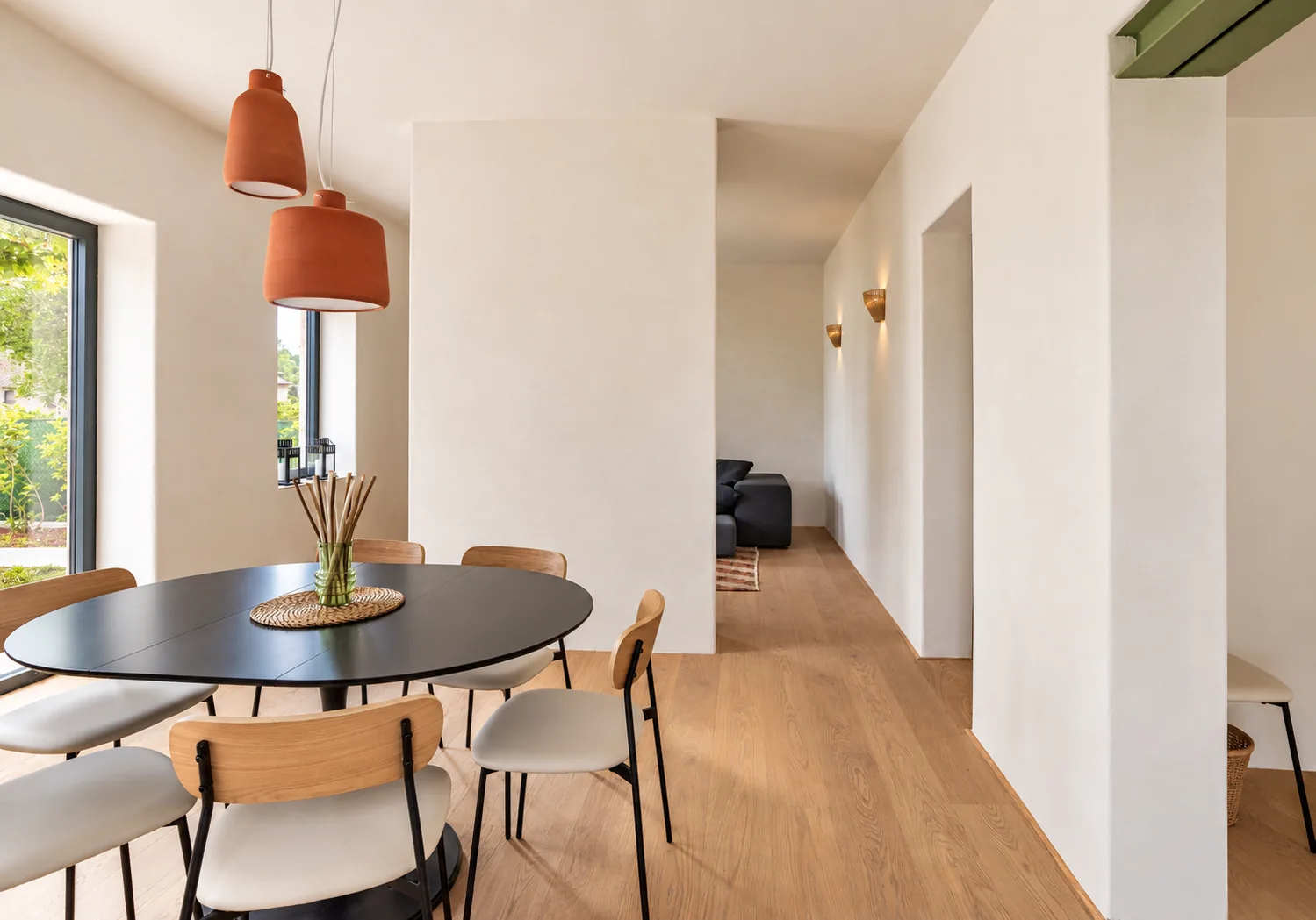 Warm contemporary kitchen-dining space with natural wood, plants and sculptural lighting