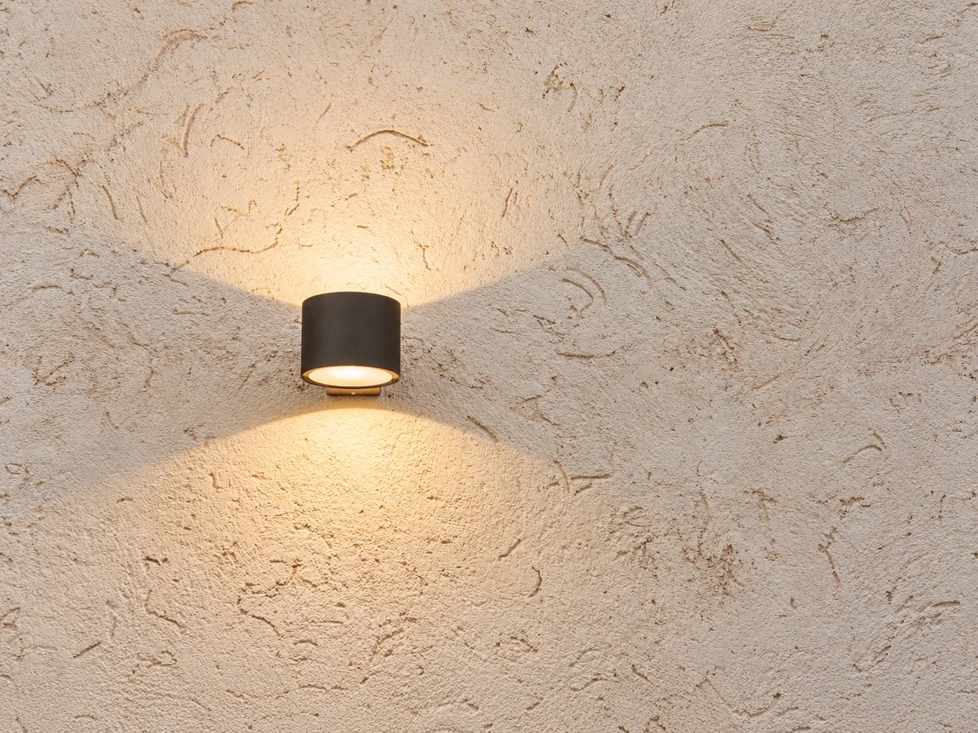 Warm wall light highlighting a textured plaster finish
